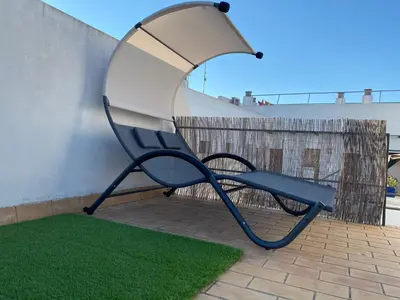 a blue chair sitting next to a wall at Atico padre Aldama centro y con WIFI in Sanlúcar de Barrameda