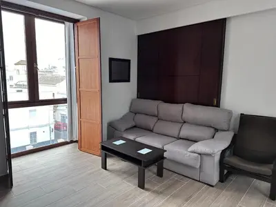 a living room with a couch and a chair at Atico padre Aldama centro y con WIFI in Sanlúcar de Barrameda