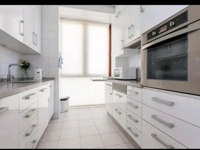 a kitchen with white cabinets and a microwave at Atico padre Aldama centro y con WIFI in Sanlúcar de Barrameda