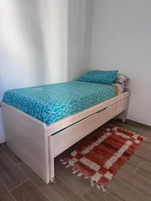 a bed sitting in a room with a rug at Atico padre Aldama centro y con WIFI in Sanlúcar de Barrameda