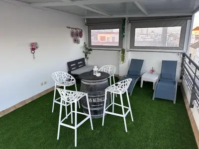 a table and chairs in a room with green grass at Atico padre Aldama centro y con WIFI in Sanlúcar de Barrameda