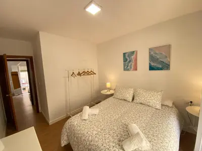 a bedroom with a large bed and a bathroom at Sánchez Home, Pleno Centro in Sanlúcar de Barrameda