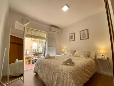 a bedroom with a large bed and a window at Sánchez Home, Pleno Centro in Sanlúcar de Barrameda