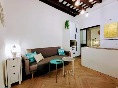 a living room with a couch and a kitchen at Apartamento Oh Cádiz in Cádiz