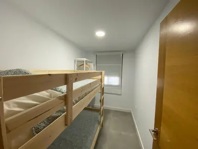 a room with two bunk beds and a door at Chalets Novo Sancti Petri in Chiclana de la Frontera