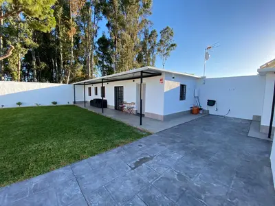 a white building with a patio and grass at Chalets Novo Sancti Petri in Chiclana de la Frontera