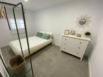 a bedroom with a bed and a mirror and a dresser at Chalets Novo Sancti Petri in Chiclana de la Frontera