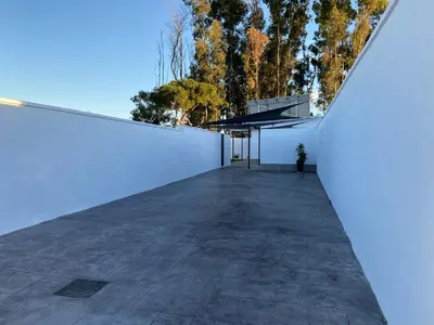 a view from the side of a white wall with a patio at Chalets Novo Sancti Petri in Chiclana de la Frontera