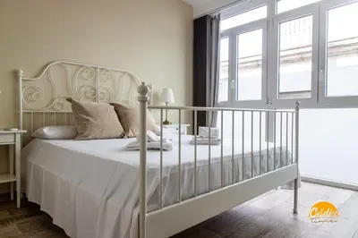 a white bedroom with a bed and a window at La Luz de Cadiz by Cadiz Time in Cádiz