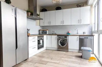 a kitchen with white cabinets and a washer and dryer at La Luz de Cadiz by Cadiz Time in Cádiz