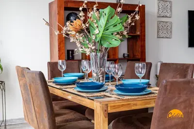a dining room table with blue dishes and a vase of flowers at La Luz de Cadiz by Cadiz Time in Cádiz
