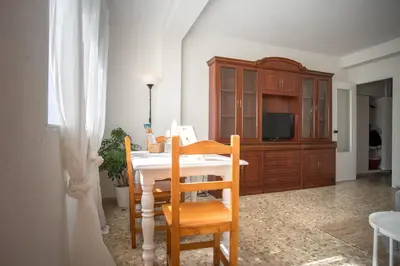 a kitchen with a table and chairs and a television at Delfín Playa Basic Ha Apartment in Cádiz