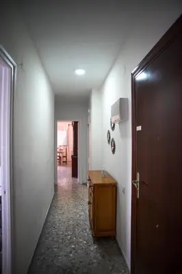 a hallway with a door and a table in a room at Delfín Playa Basic Ha Apartment in Cádiz
