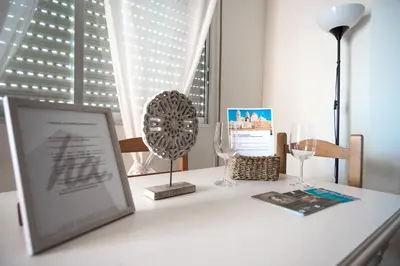 a table with a picture and wine glasses on it at Delfín Playa Basic Ha Apartment in Cádiz