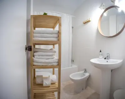 a bathroom with a wooden towel rack next to a sink at Delfín Playa Basic Ha Apartment in Cádiz
