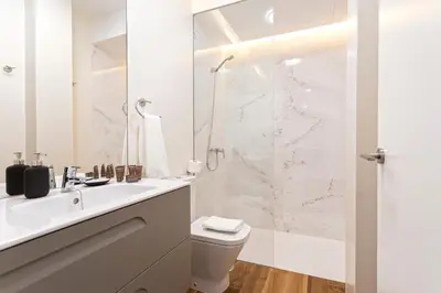 a white bathroom with a shower and a toilet at Genteel Home San Antonio in Cádiz