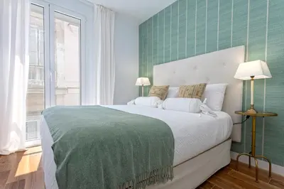 a bedroom with a large bed with a green wall at Genteel Home San Antonio in Cádiz