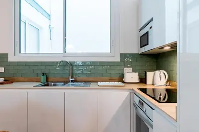 a kitchen with white cabinets and a sink at Genteel Home San Antonio in Cádiz