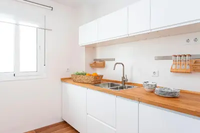 a kitchen with white cabinets and a sink at Genteel Home San Antonio in Cádiz