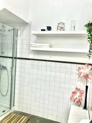 a bathroom with a shower and white tiled walls at El rinconcito de Robles in Cádiz