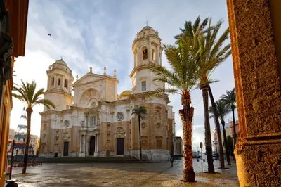 a large building with palm trees in front of it at El rinconcito de Robles in Cádiz