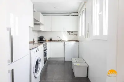 a white kitchen with a washer and dryer at Apartamento Vintage by Cadiz Time in Cádiz