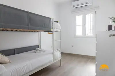 a bedroom with a bunk bed and a window at Apartamento Vintage by Cadiz Time in Cádiz