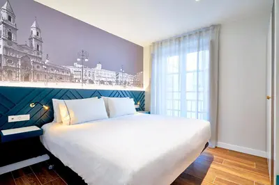 a bedroom with a large bed with a mural of a city at Tandem Torres de Cádiz Suites in Cádiz