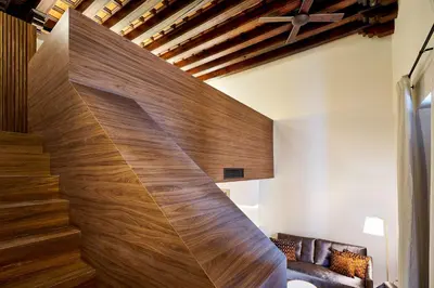 a staircase in a living room with wood paneling at Tandem Torres de Cádiz Suites in Cádiz