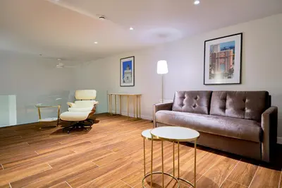 a living room with a couch and a table and chairs at Tandem Torres de Cádiz Suites in Cádiz