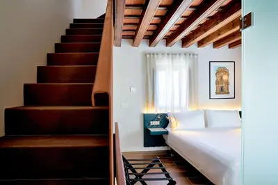 a bedroom with a bed next to a staircase at Tandem Torres de Cádiz Suites in Cádiz