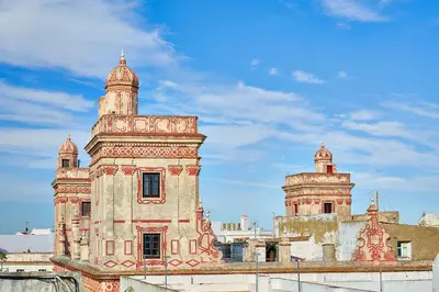 an old building with two towers on top of it at Tandem Torres de Cádiz Suites in Cádiz
