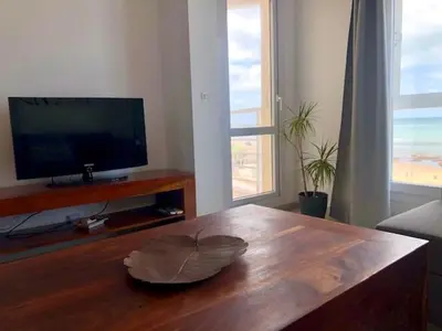 a living room with a wooden coffee table and a television at GATU Vista Infinita 1ªlinea mar WIFI, AIRE ACC, TERRAZA CON VISTAS in Cádiz