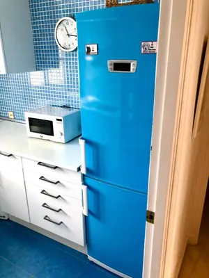 a blue cabinet in a kitchen with a microwave at GATU Vista Infinita 1ªlinea mar WIFI, AIRE ACC, TERRAZA CON VISTAS in Cádiz