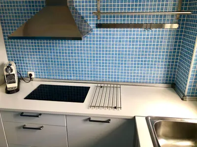 a kitchen with blue tiles on the wall and a sink at GATU Vista Infinita 1ªlinea mar WIFI, AIRE ACC, TERRAZA CON VISTAS in Cádiz