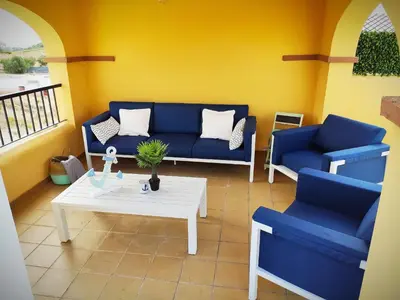 a living room with two blue couches and a table at El ático de los flamencos, Apartamentos Living Sur in Sanlúcar de Barrameda