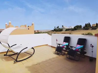 two chairs sitting on the roof of a house at El ático de los flamencos, Apartamentos Living Sur in Sanlúcar de Barrameda