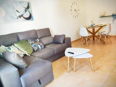 a living room with a couch and a table at El ático de los flamencos, Apartamentos Living Sur in Sanlúcar de Barrameda