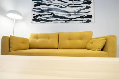 a yellow couch in a living room with a painting at Apartamento Colon en Cadiz in Cádiz