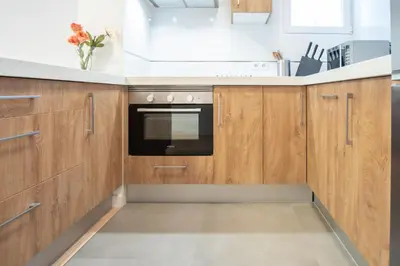a kitchen with wooden cabinets and a black oven at Apartamento Colon en Cadiz in Cádiz