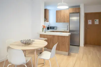 a kitchen with a table and chairs and a refrigerator at Apartamento Colon en Cadiz in Cádiz