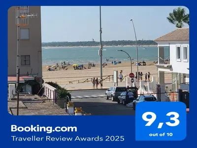 a view of a beach with people on the sand at Apartamento Campoamor in Sanlúcar de Barrameda