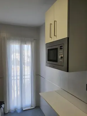 a kitchen with a microwave and a window at Apartamento Campoamor in Sanlúcar de Barrameda