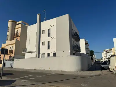 a large white building on the side of a street at Apartamento Campoamor in Sanlúcar de Barrameda
