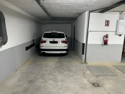 a white car is parked in a garage at Apartamento Campoamor in Sanlúcar de Barrameda