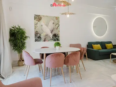 a living room with a table and chairs at DUPLEX NUEVO CONVENTO PLAZA CABILDO in Sanlúcar de Barrameda