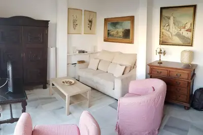 a living room with a couch and a table and chairs at Apartamento Las Infantas. Centro de Sanlucar. in Sanlúcar de Barrameda