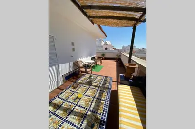 a balcony with a view of a building with a roof at Apartamento Las Infantas. Centro de Sanlucar. in Sanlúcar de Barrameda