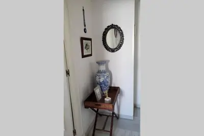 a hallway with a vase on a table and a mirror at Apartamento Las Infantas. Centro de Sanlucar. in Sanlúcar de Barrameda