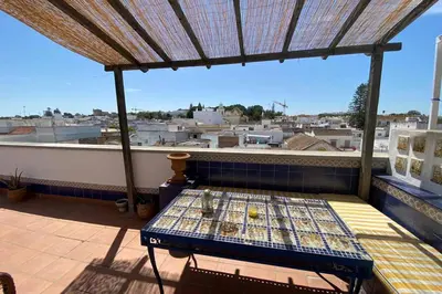 a balcony with a table and a view of a city at Apartamento Las Infantas. Centro de Sanlucar. in Sanlúcar de Barrameda